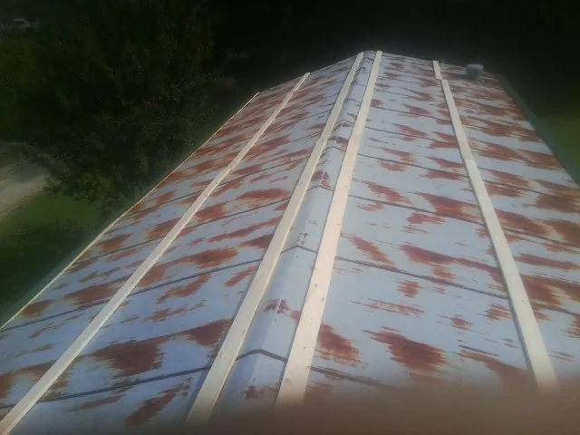 Rusted metal roof panels with new wood purlins before replacement — Storm Damage Roof Repair in Nicholls by Roofing Brothers